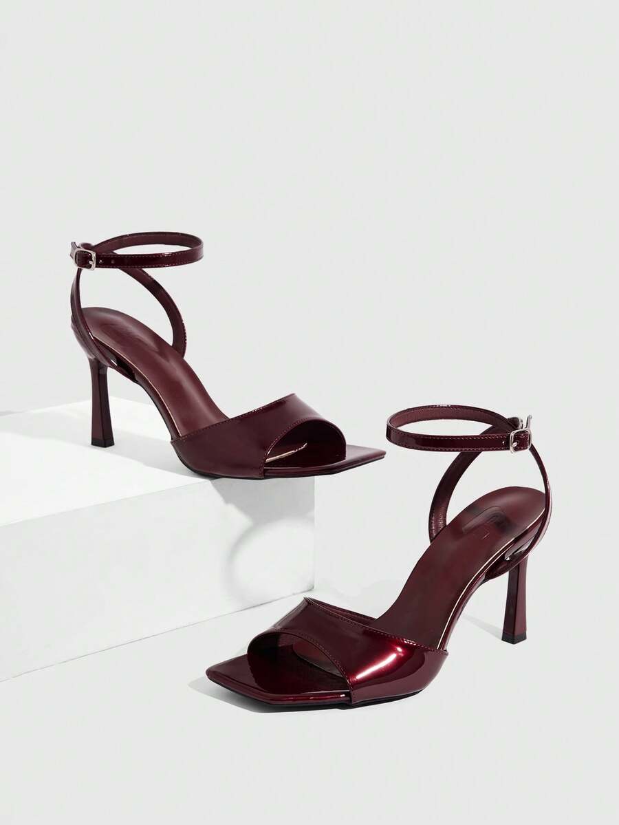 Women's peep toe ankle strap high heel sandals featuring a sleek stiletto heel and adjustable buckle closure.