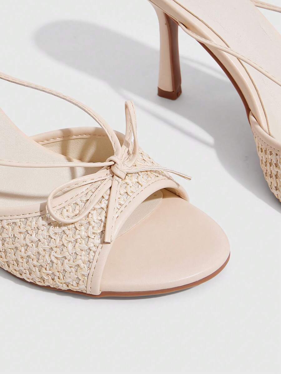 Elegant high heel sandals with romantic bow strap and slim stiletto heel for party and wedding occasions.