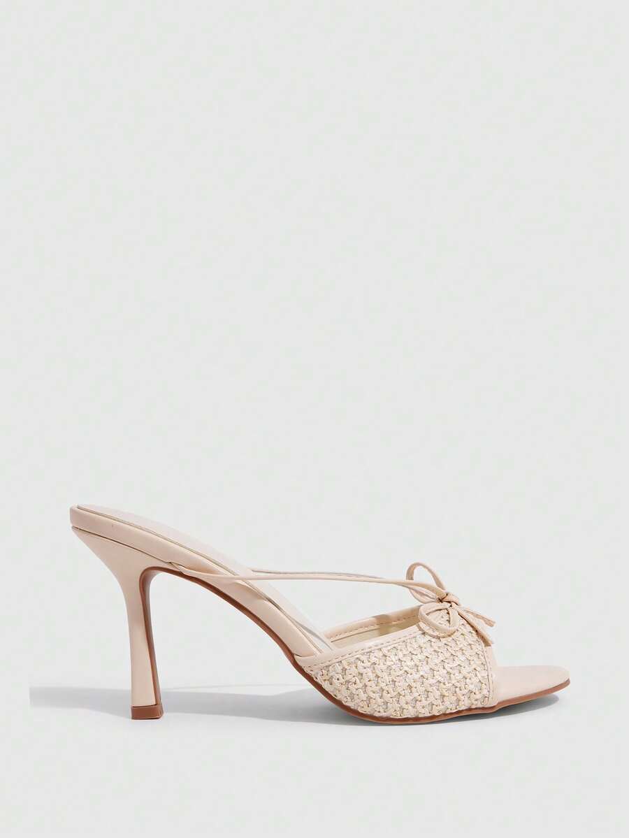 Elegant high heel sandals with romantic bow strap and slim stiletto heel for party and wedding occasions.