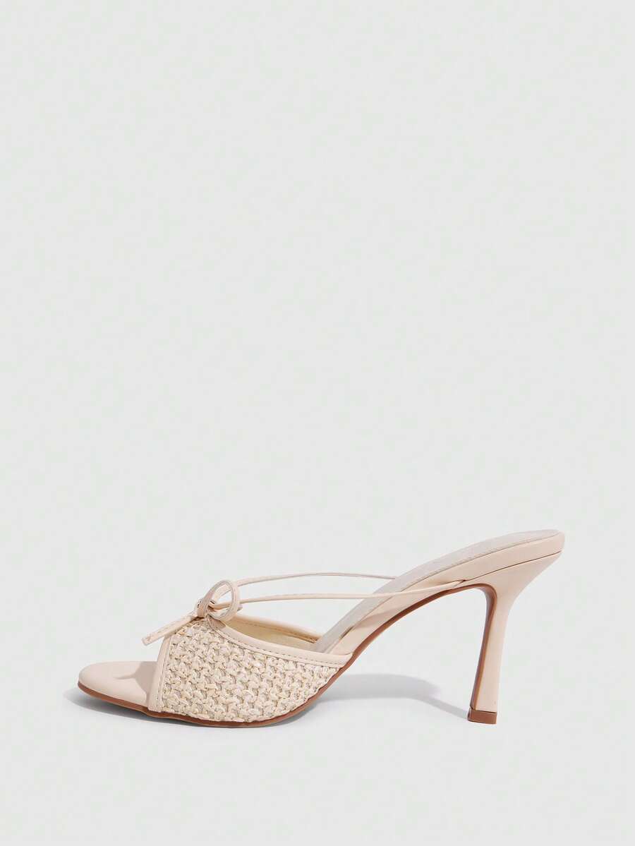 Elegant high heel sandals with romantic bow strap and slim stiletto heel for party and wedding occasions.