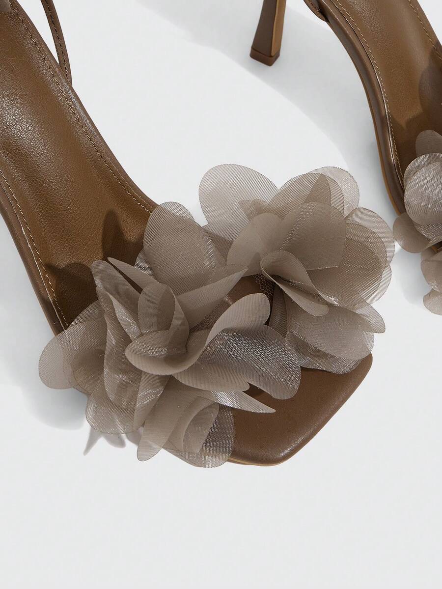 Women's open toe heeled sandals featuring 3D floral decor, satin lace-up ankle straps, and stiletto high heels.