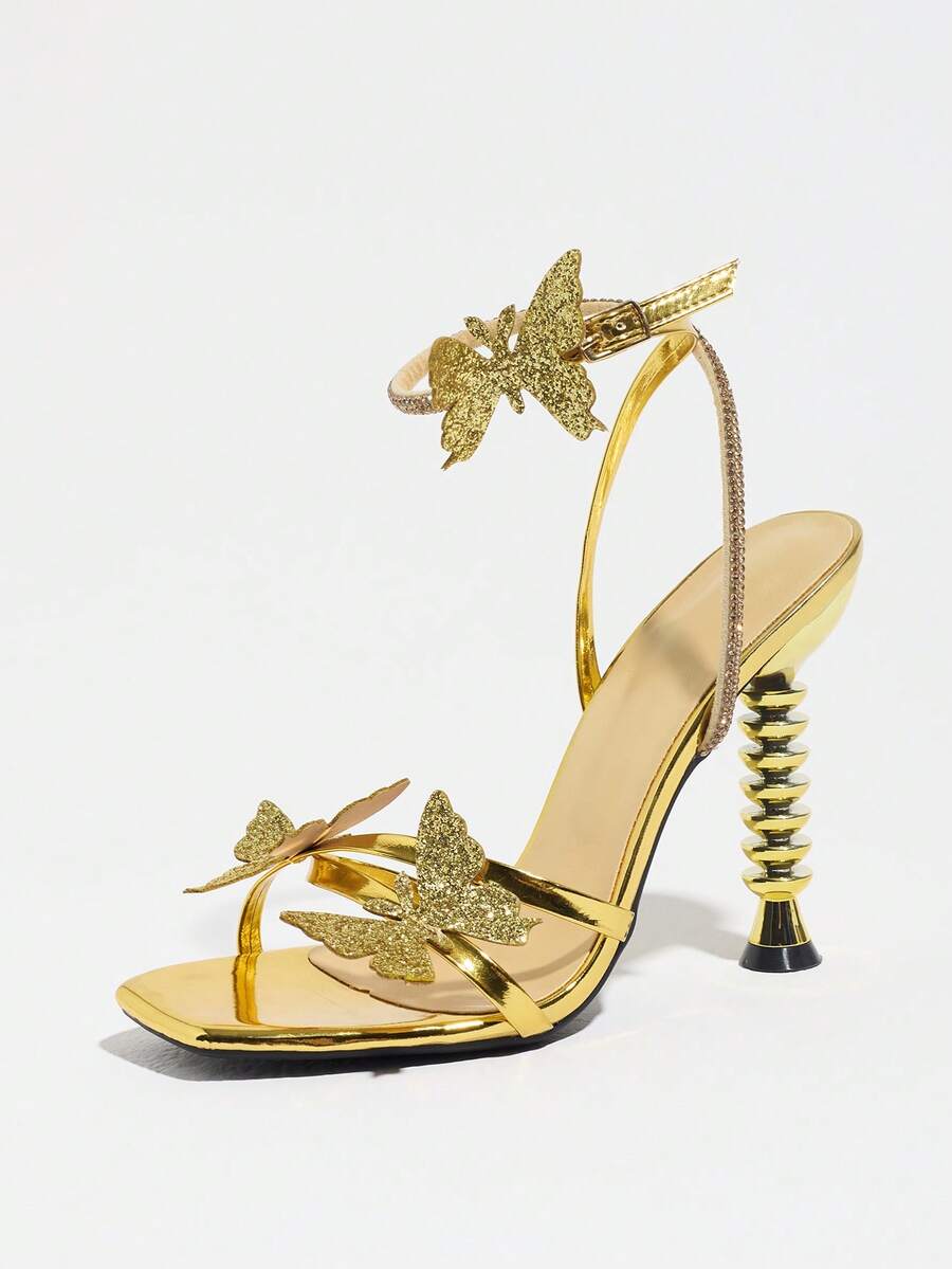 Women's gold high heel sandals featuring open toe, stiletto heel, bow accent, and adjustable ankle strap.