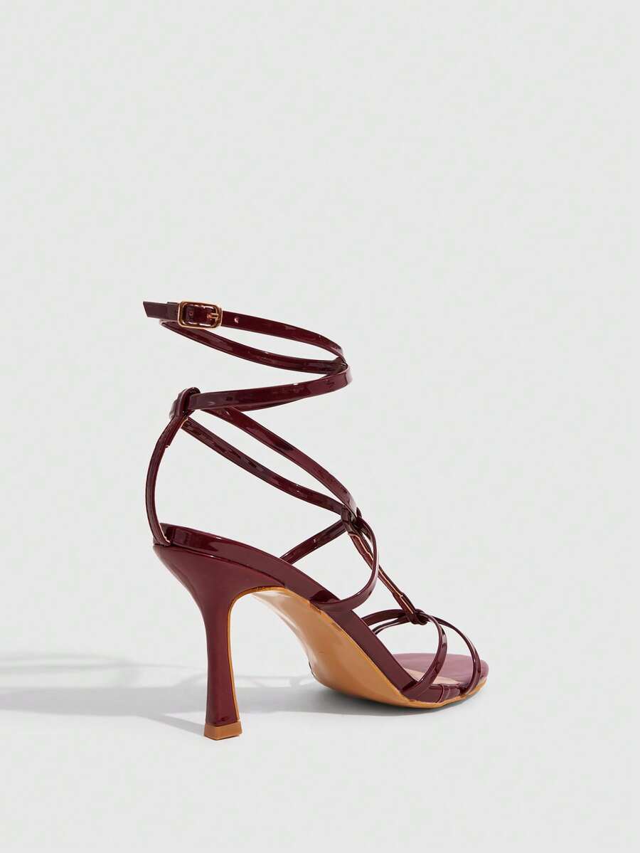 Women's open round toe high heel sandals with thin stiletto heel, hollow strap design, and ankle buckle closure.