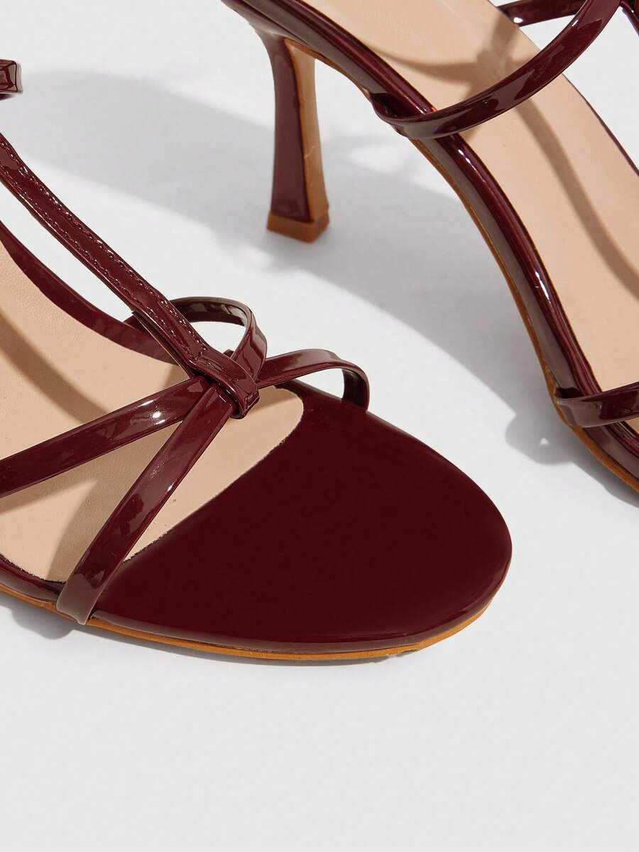 Women's open round toe high heel sandals with thin stiletto heel, hollow strap design, and ankle buckle closure.