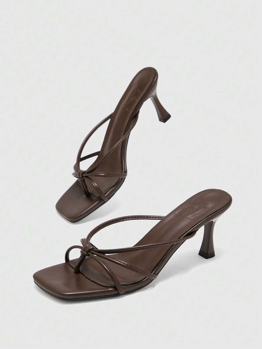 Square toe stiletto heel thong sandals for women featuring thin toe post strap, knot detail, and mid pyramid heel.
