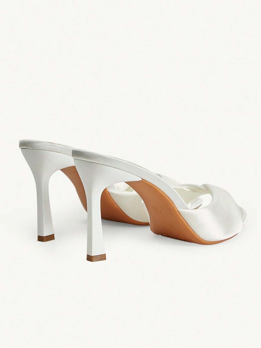 Women's peep toe high-heeled stiletto sandals with slingback strap in light metallic finish.