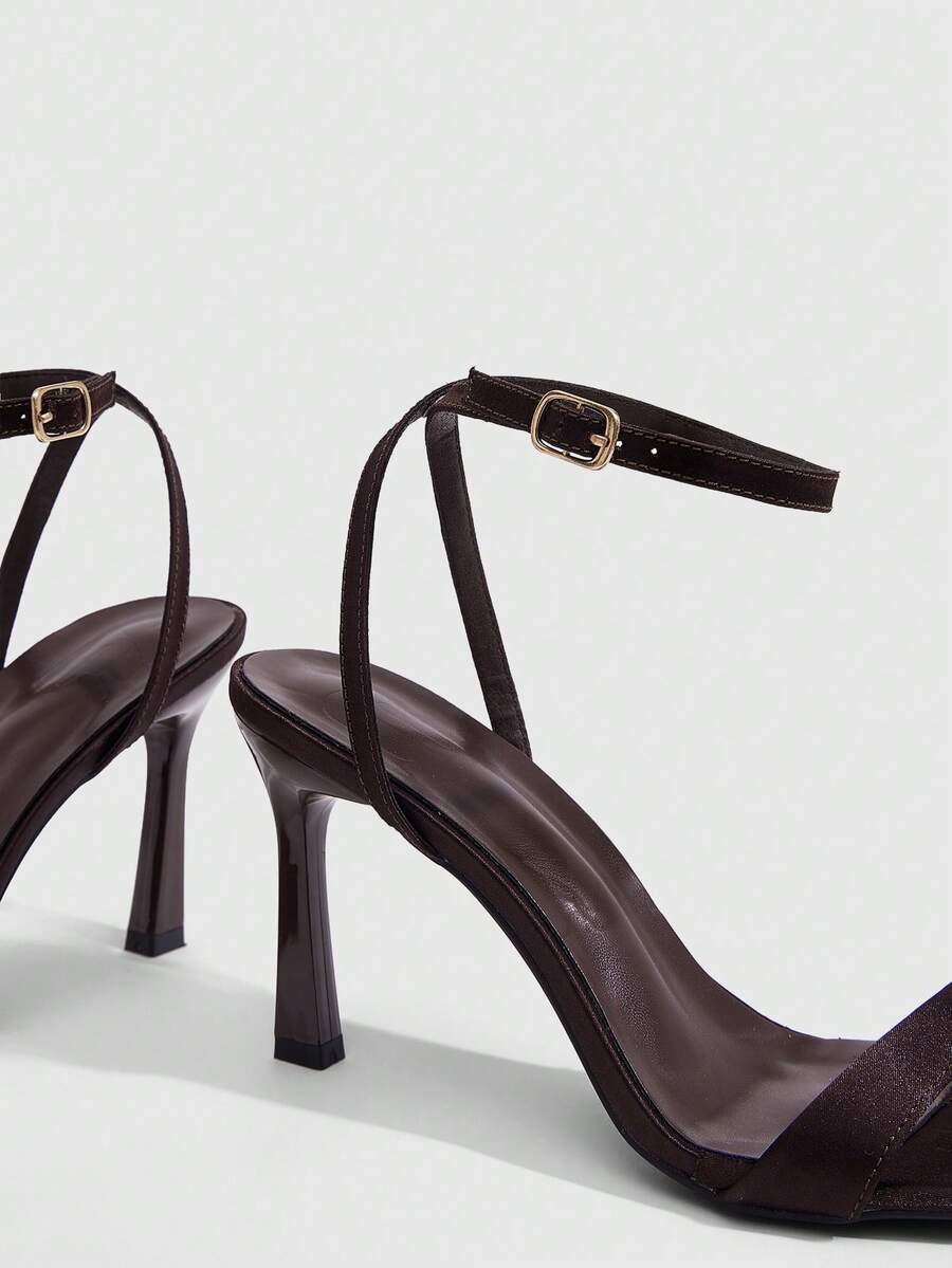 Women's high heel ankle strap sandals with open toe and stiletto heel in mirror black finish.