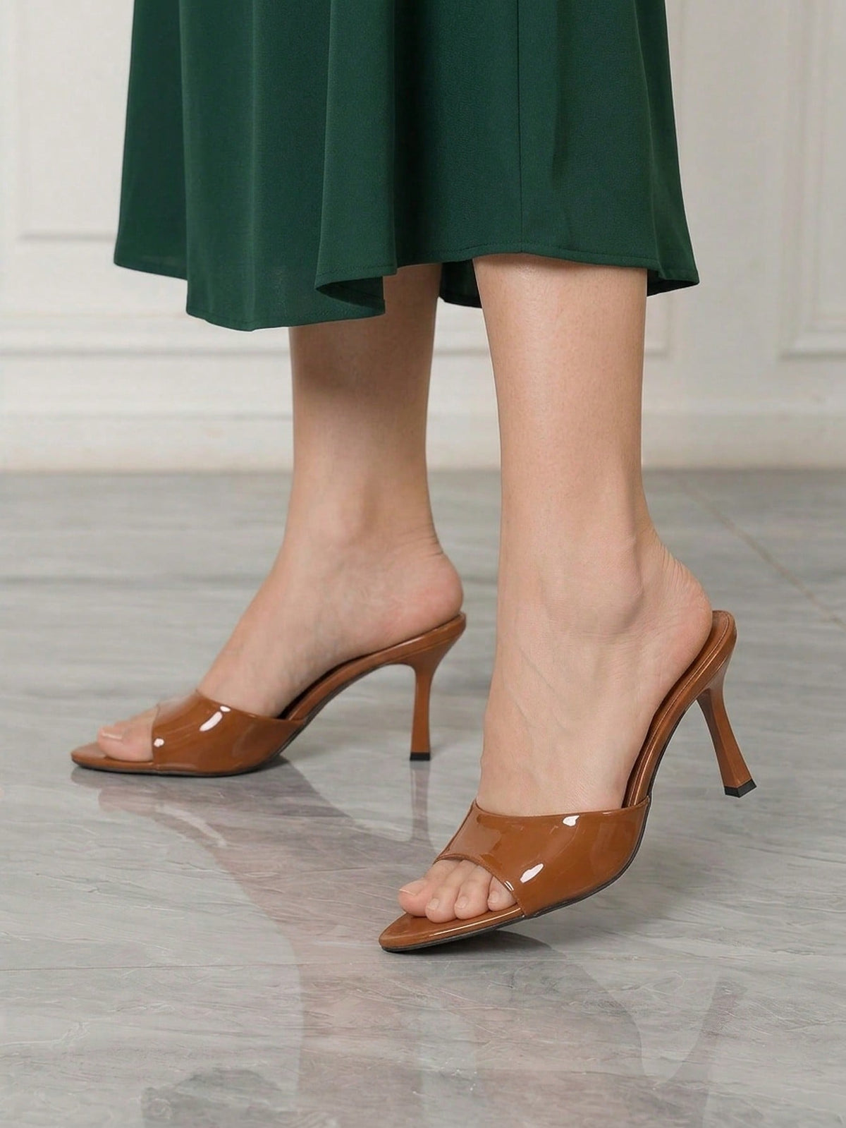 Women's high-heeled slippers in PU leather featuring an open plain toe, belt detail, and stiletto high heel with TPR outsole.