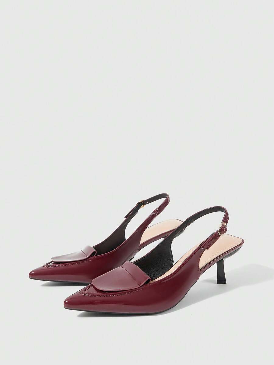 Women's pointed-toe high heel pumps in black mirror PU leather with an ankle strap, stiletto heel, and rhinestone buckle.