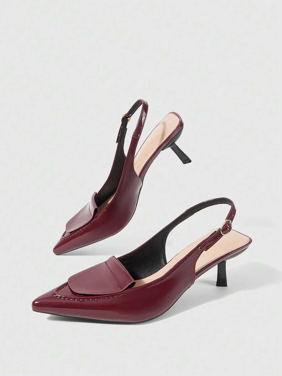 Women's pointed-toe high heel pumps in black mirror PU leather with an ankle strap, stiletto heel, and rhinestone buckle.