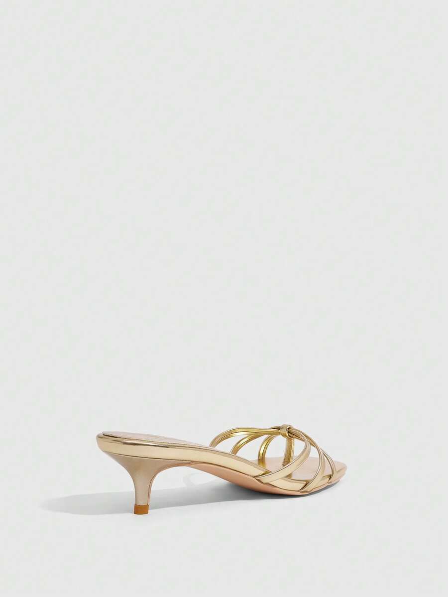 Square toe gold metallic heel sandals for women featuring open toe, crossover slingback strap, and stiletto mid heel for weddings and parties.