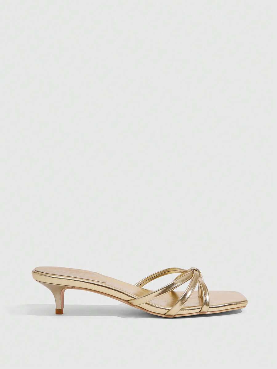 Square toe gold metallic heel sandals for women featuring open toe, crossover slingback strap, and stiletto mid heel for weddings and parties.