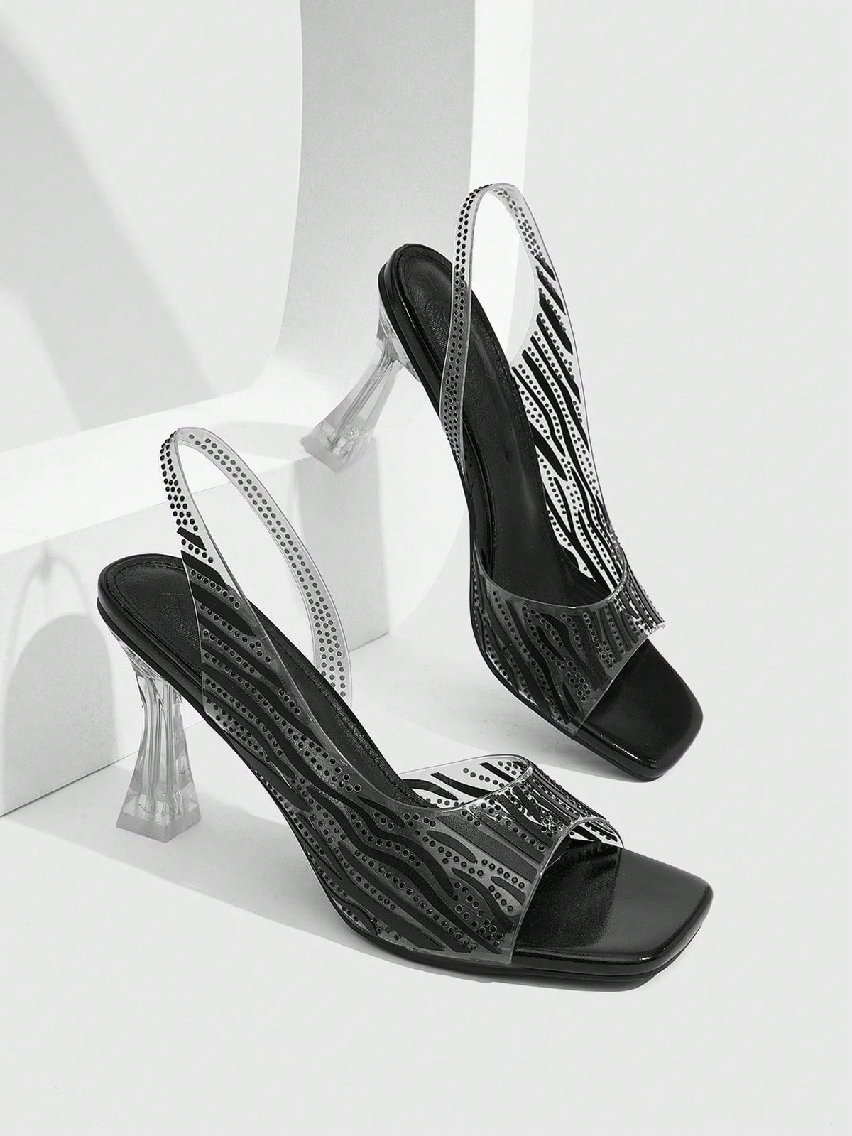 Women's square toe heeled sandals with clear straps, sparkling rhinestone embellishments, and a high pyramid heel.