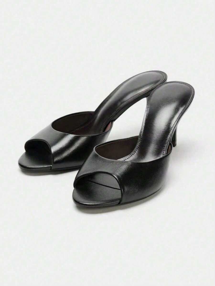 Pair of women's open toe patent leather mule shoes with sleek stiletto heels and cut-out styling