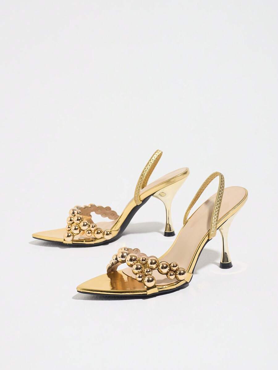 Pointed toe party high heels in gold featuring wavy lace trim, a stiletto heel, and back tie slingback straps.