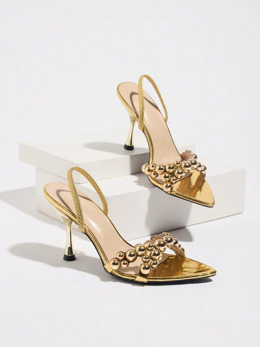 Pointed toe party high heels in gold featuring wavy lace trim, a stiletto heel, and back tie slingback straps.