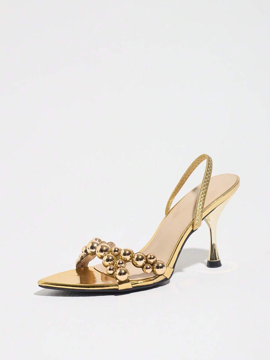 Pointed toe party high heels in gold featuring wavy lace trim, a stiletto heel, and back tie slingback straps.