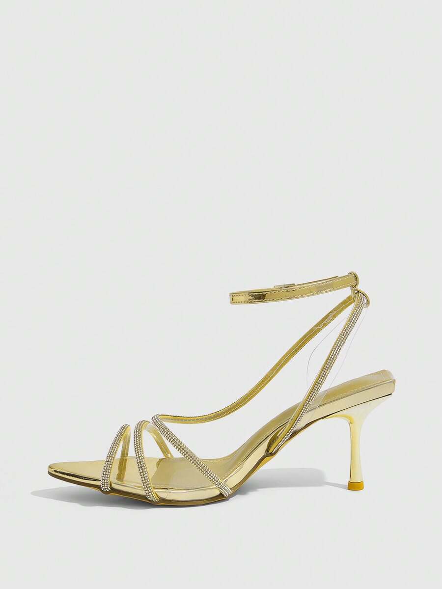 Women's gold open toe high heel sandals featuring sparkling rhinestone ankle strap and transparent upper
