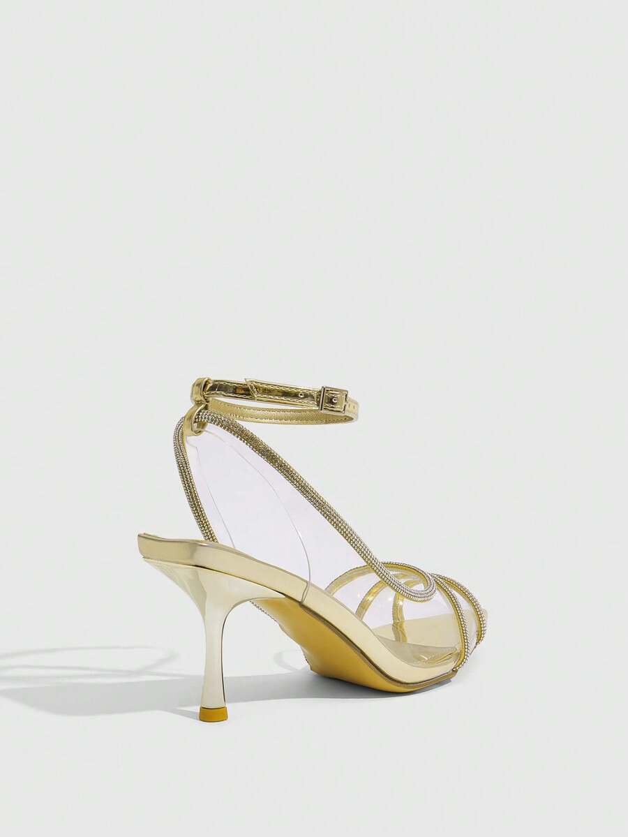 Women's gold open toe high heel sandals featuring sparkling rhinestone ankle strap and transparent upper
