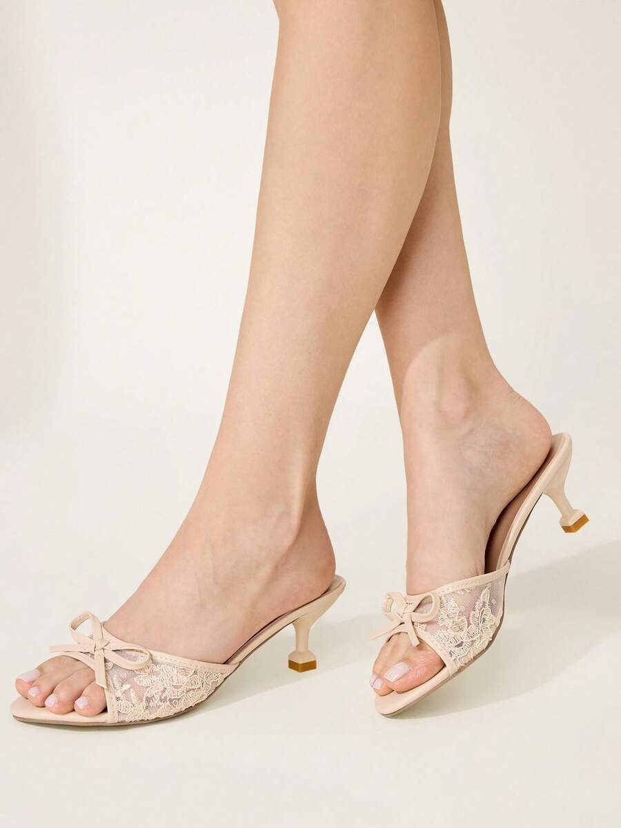 Open toe high heel slide sandals featuring lace details and a bow accent on the upper strap.