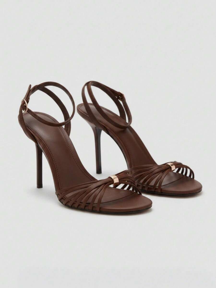 Women's open toe stiletto high heel sandals featuring metallic knot decor and an adjustable ankle buckle strap.