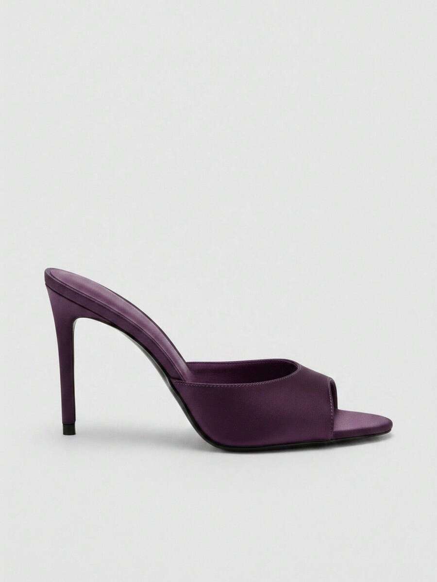 Pair of women's open toe patent leather mule shoes with sleek stiletto heels and cut-out styling