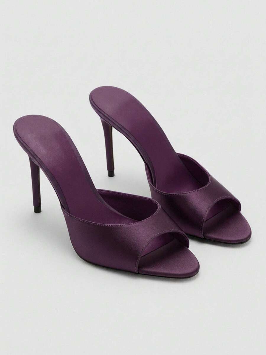 Pair of women's open toe patent leather mule shoes with sleek stiletto heels and cut-out styling