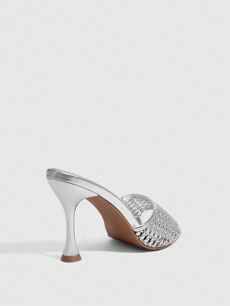 Pair of women's pointed toe stiletto mule sandals with shiny patent upper and slip-on design.