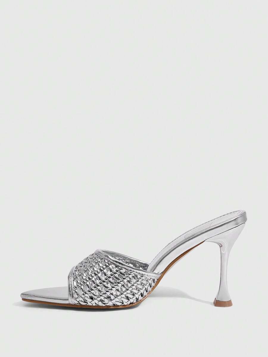 Pair of women's pointed toe stiletto mule sandals with shiny patent upper and slip-on design.