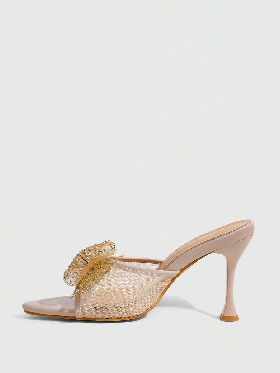 Pair of women's pointed toe stiletto mule sandals with shiny patent upper and slip-on design.