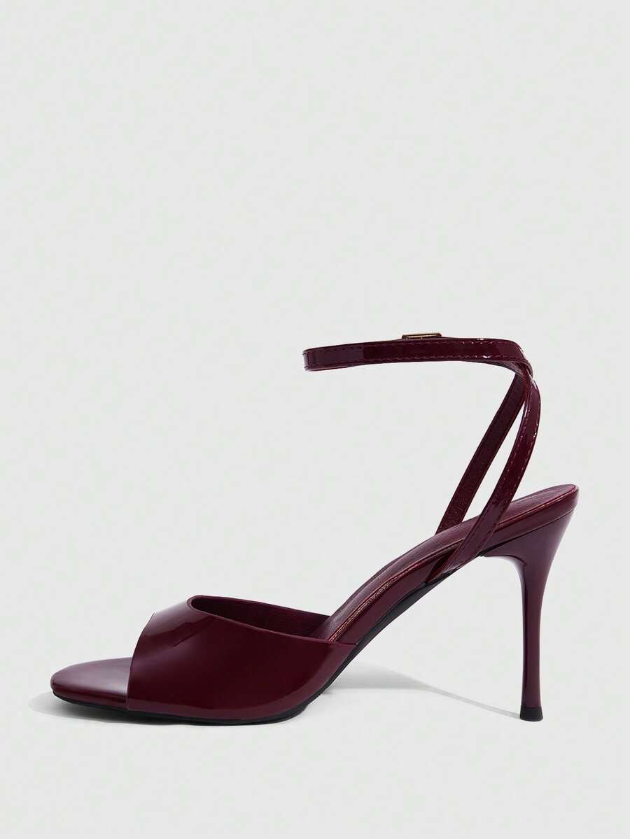 Women's patent leather stiletto sandals with open toe and ankle buckle strap