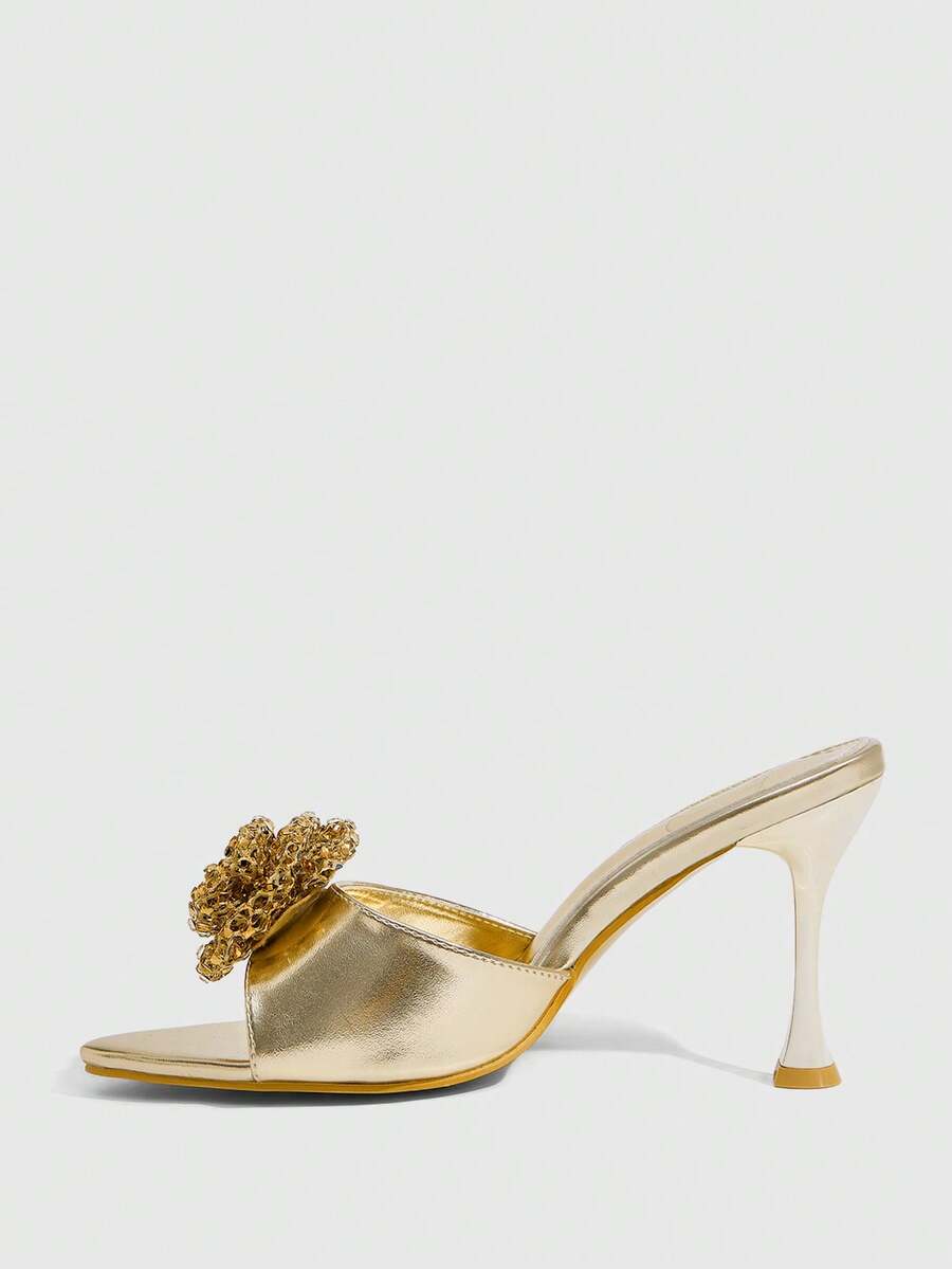 Pair of women's pointed toe stiletto mule sandals with shiny patent upper and slip-on design.