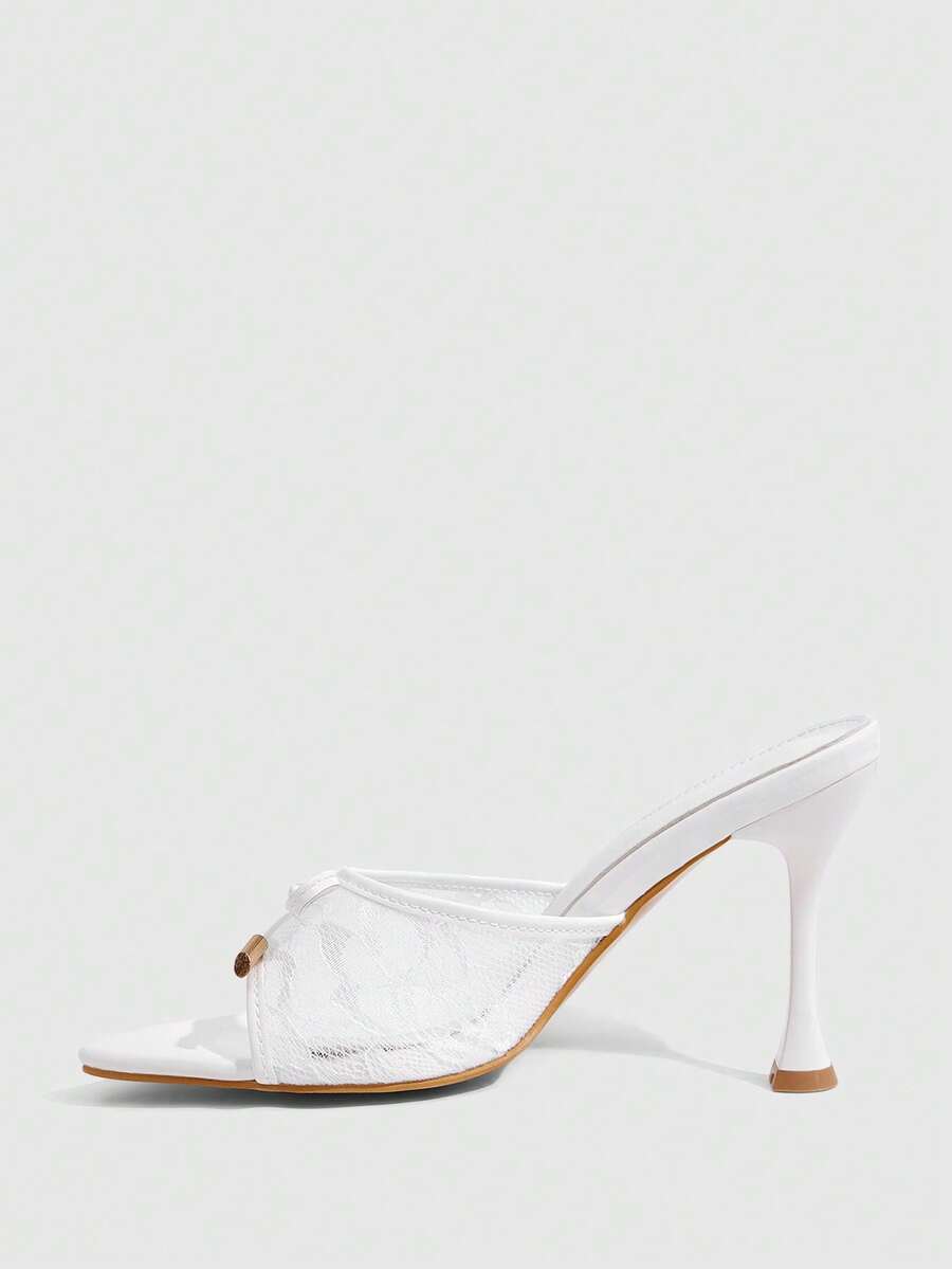 Pair of women's pointed toe stiletto mule sandals with shiny patent upper and slip-on design.