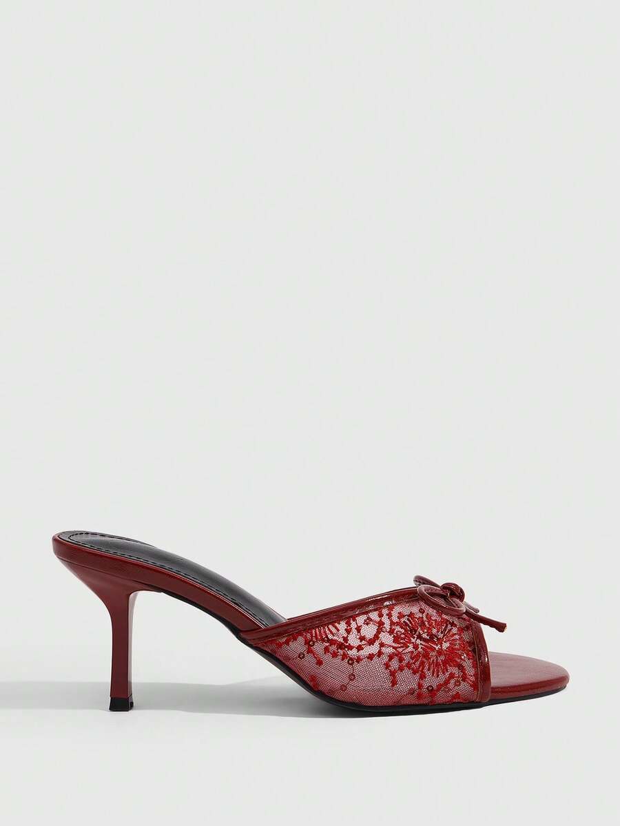 Open toe high heel slide sandals featuring lace details and a bow accent on the upper strap.