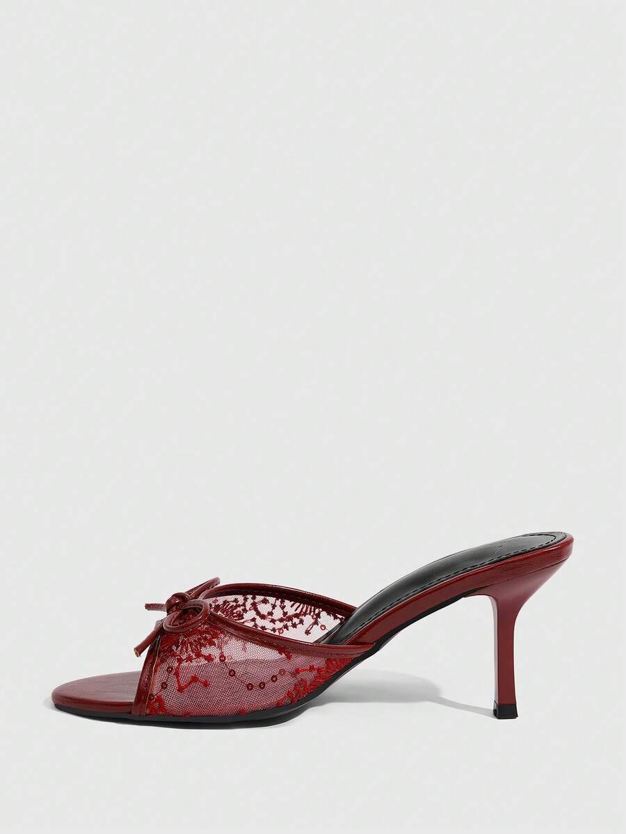 Open toe high heel slide sandals featuring lace details and a bow accent on the upper strap.