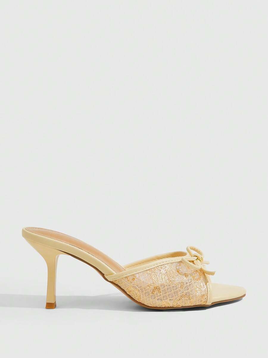 Open toe high heel slide sandals featuring lace details and a bow accent on the upper strap.