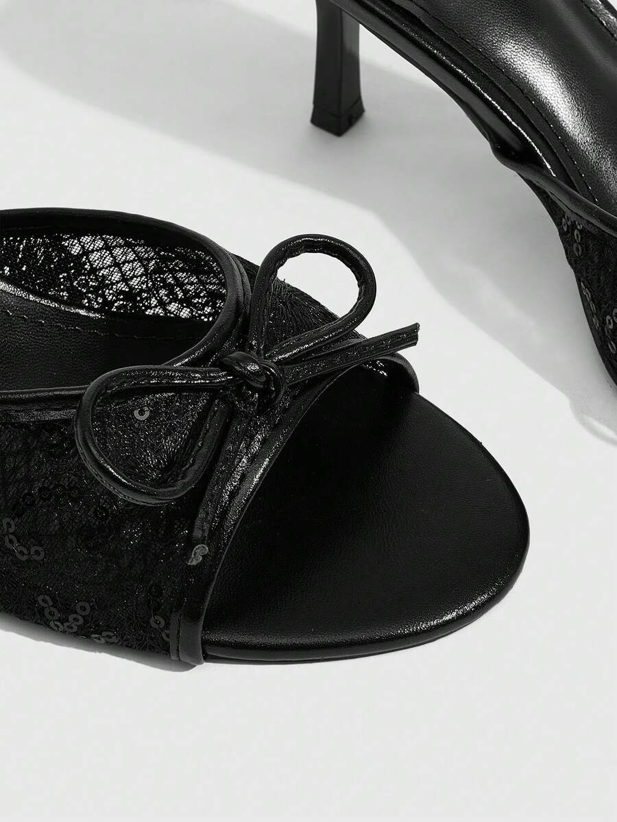 Open toe high heel slide sandals featuring lace details and a bow accent on the upper strap.