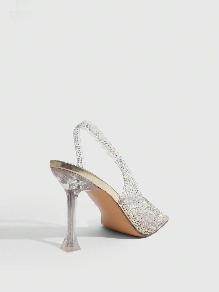 Women's square toe heeled sandals with clear straps, sparkling rhinestone embellishments, and a high pyramid heel.