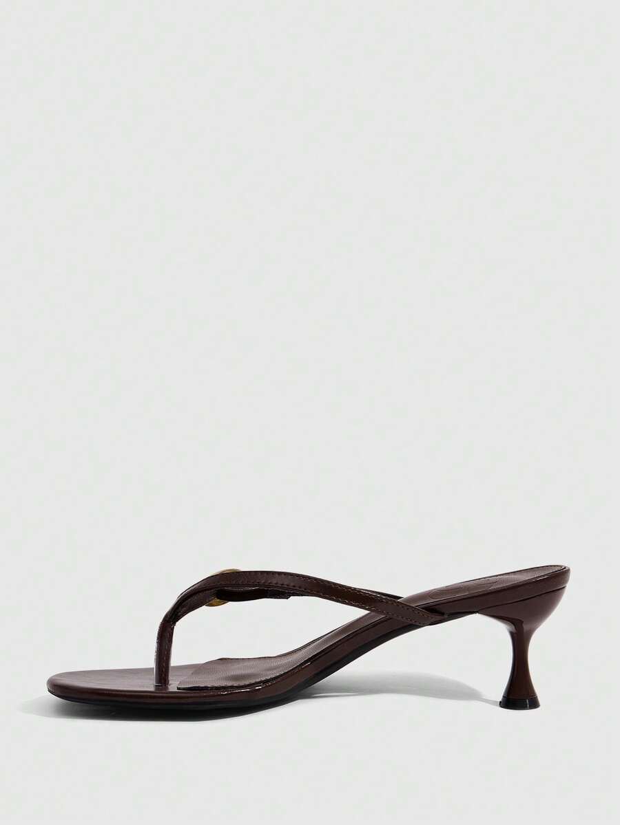 Women's slingback heeled sandals featuring a button toe post accent, sleek mid pyramid heel, and smooth faux leather finish.