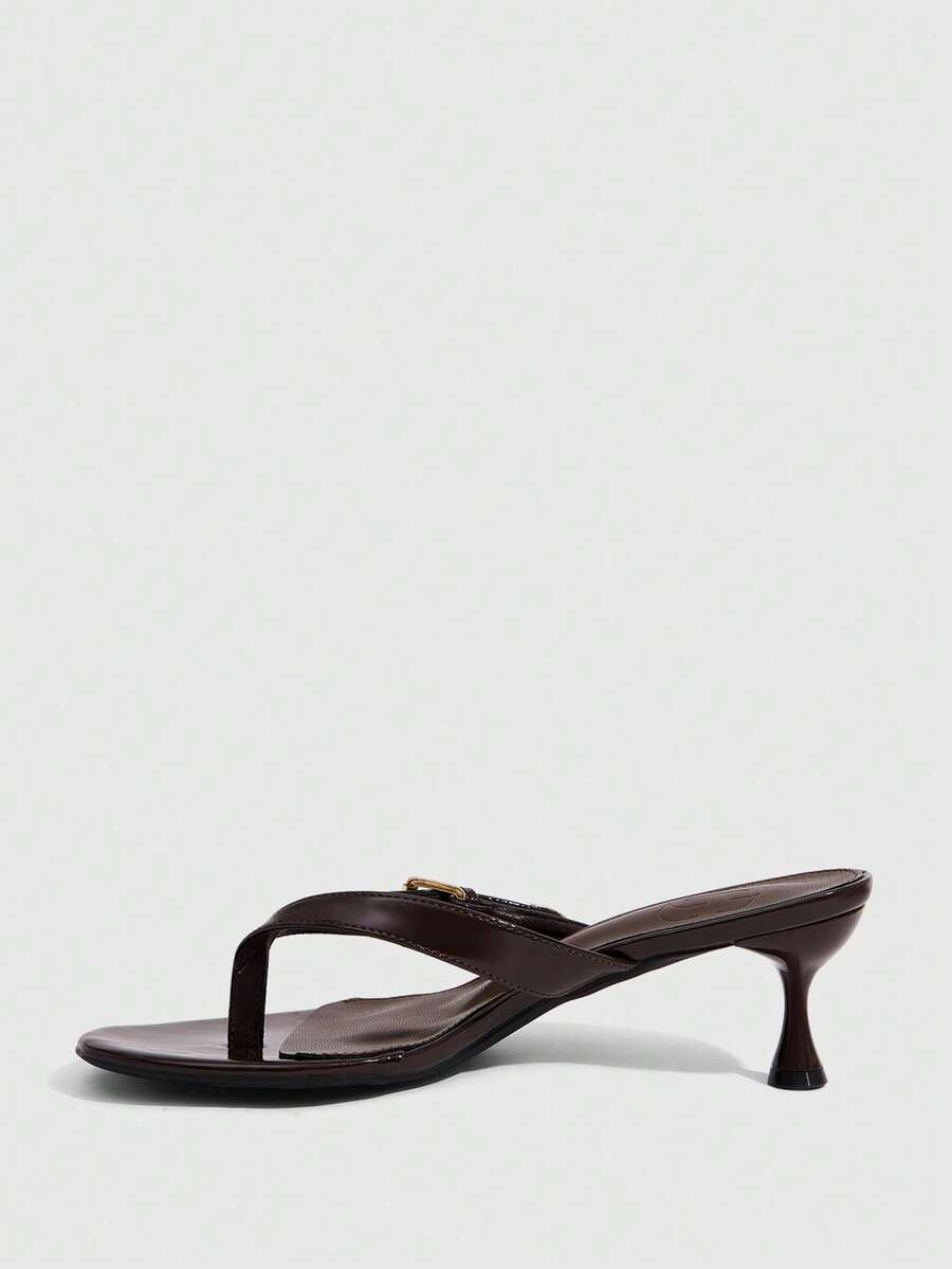 Women's patent leather heeled sandals featuring a toe post strap with metal buckle and mid pyramid heel.