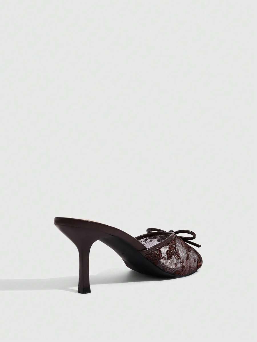 Open toe high heel slide sandals featuring lace details and a bow accent on the upper strap.