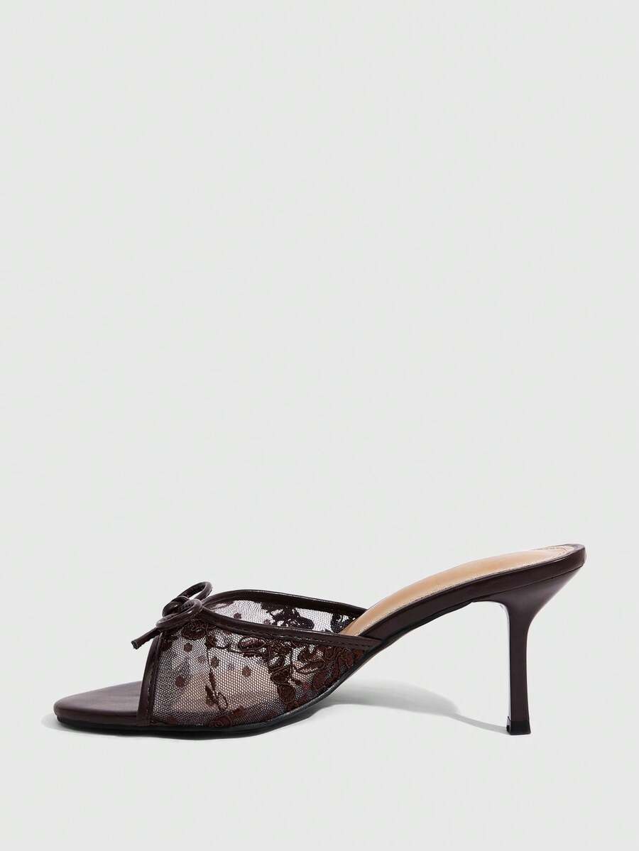 Open toe high heel slide sandals featuring lace details and a bow accent on the upper strap.
