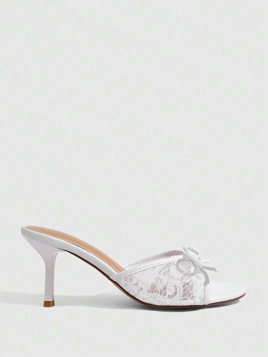 Open toe high heel slide sandals featuring lace details and a bow accent on the upper strap.
