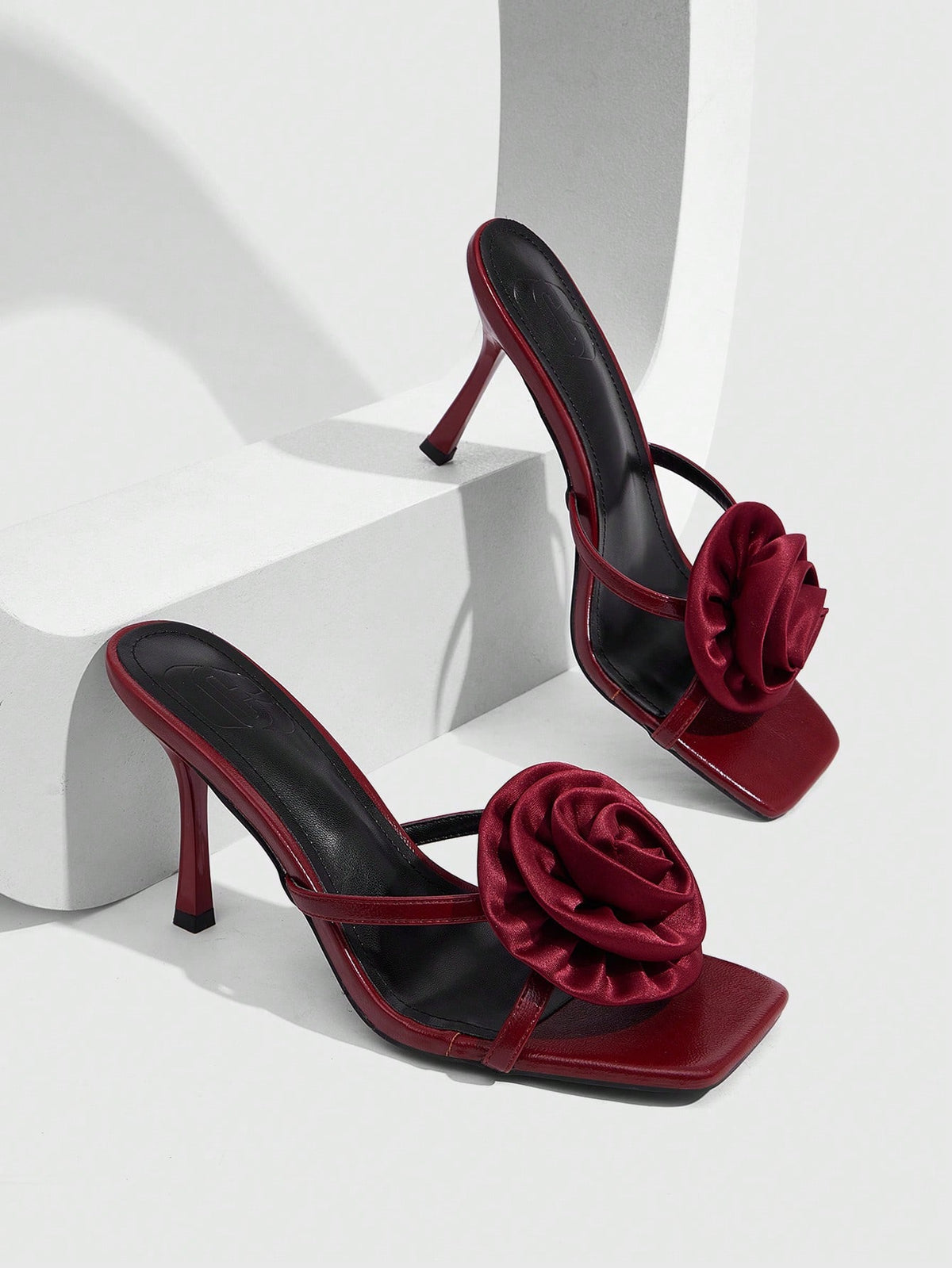 Women's open toe satin slip-on heeled sandals featuring an elegant flower accent and high stiletto heel.