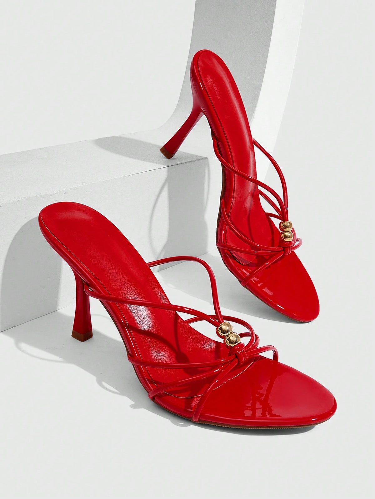 Burgundy stiletto high heel sandals featuring open toe thin straps and knot details