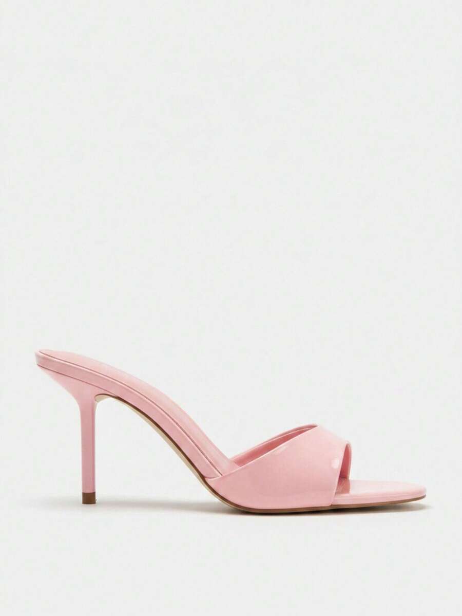 Pair of women's open toe patent leather mule shoes with sleek stiletto heels and cut-out styling