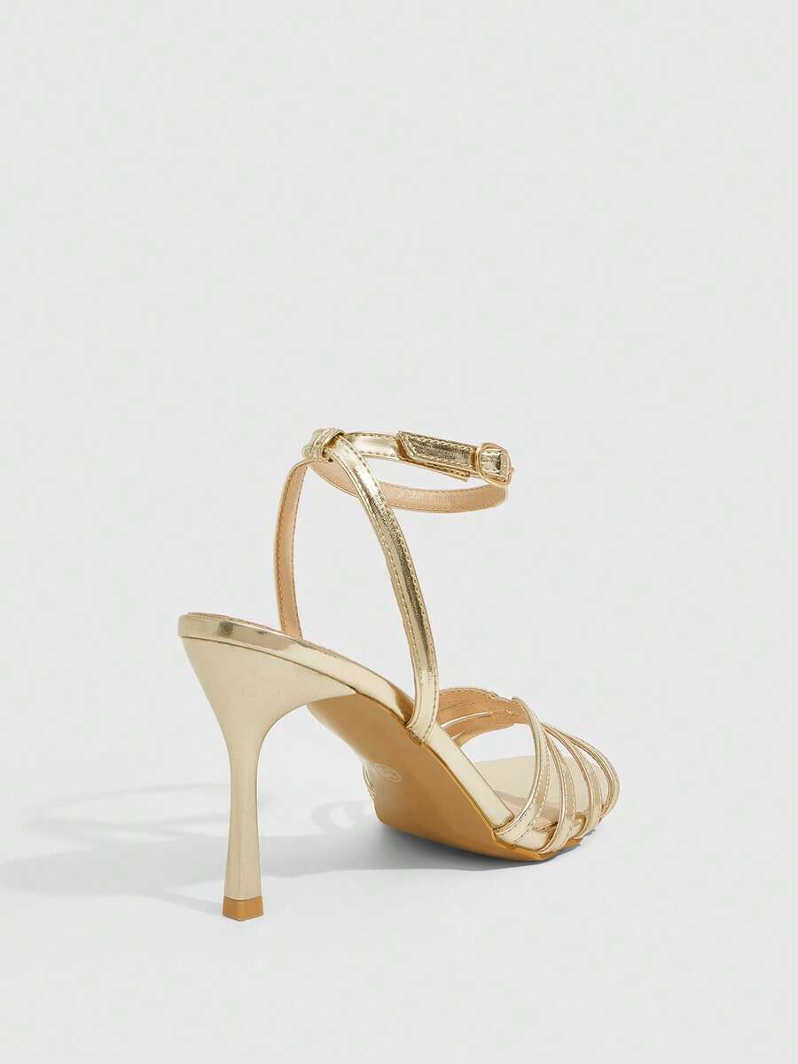 Women's champagne stiletto high heel sandals featuring knotted cross-over straps, open round toe, and adjustable ankle buckle strap.