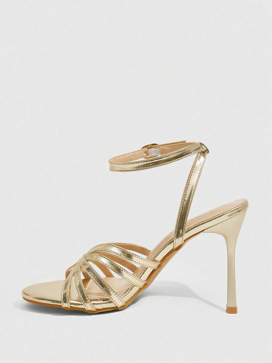 Women's champagne stiletto high heel sandals featuring knotted cross-over straps, open round toe, and adjustable ankle buckle strap.