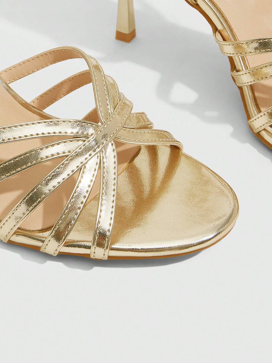 Women's champagne stiletto high heel sandals featuring knotted cross-over straps, open round toe, and adjustable ankle buckle strap.