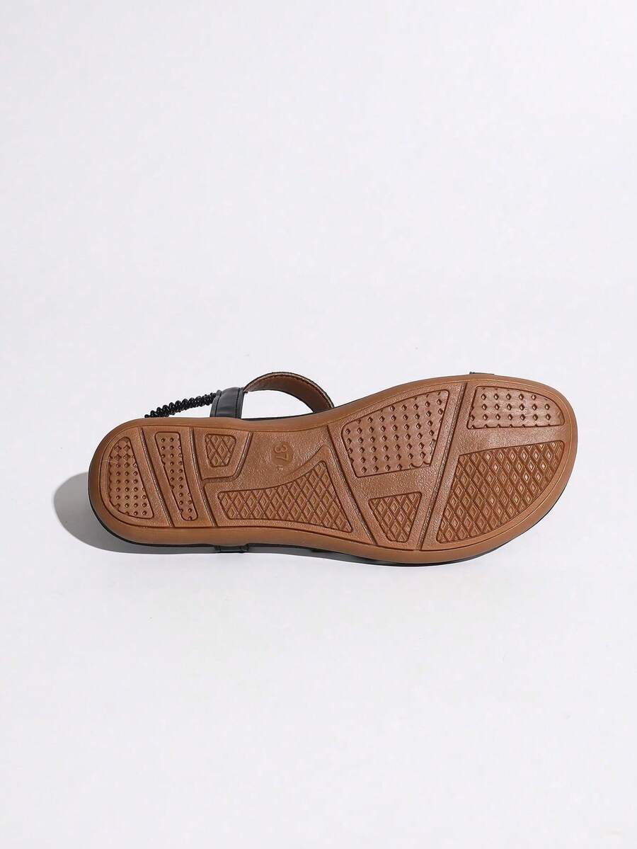 Women's lace-up flat slip-on sandals with round toe and hollow-out PU leather straps for beach and daily wear.